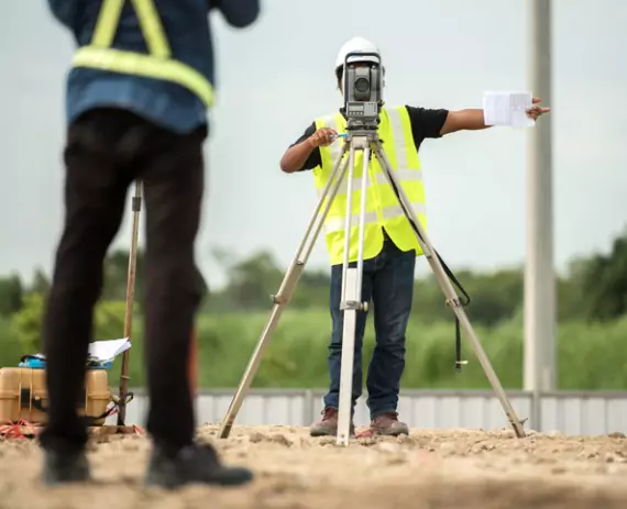Two land surveyors work on a project for Austin Engineering, which are Civil Engineers in Moline IL