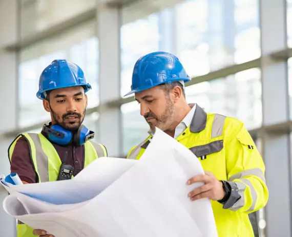 Two civil engineers from Austin Engineering review plans for a commercial project after providing Drone Surveys in Bloomington IL