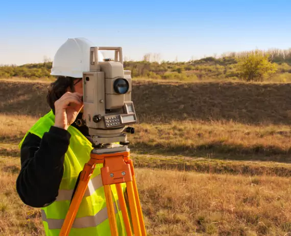 A team member of Austin Engineering Survey Crews in Champaign IL work on a parcel of land.